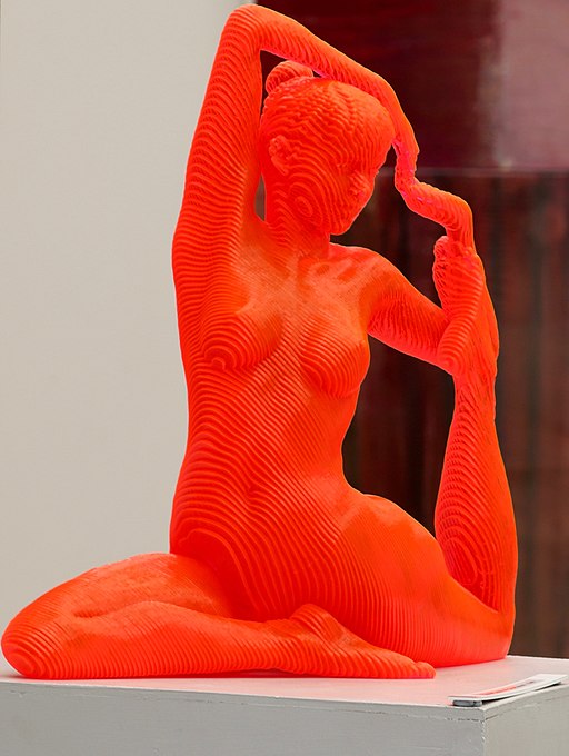 Red statue of a woman doing a yoga pose.